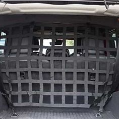 the back end of a car with its cargo area covered in black plastic mesh material