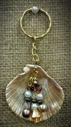 a shell keychain with pearls and other charms