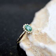 18K Emerald and Brilliant Diamonds Engagement Ring, 0.45ct Natural Emerald Gold Ring, 18K Brilliant Diamonds Wedding Ring, Gift For Her ⚜️Weight: 6.0gr   💎Gemstone: Emerald 0.45ct  💎Gemstone: 14 Diamonds of 0.15ct each Beautiful and unique 18K gold Diana emerald ring set with 1 emerald and 14 small diamonds.  🦚 Visit my gemstone rings collection:  https://www.etsy.com/shop/noahconcept/?etsrc=sdt&fbclid=PAAabX3la4ZzrGRug-fdx0AVTcM8lpjsQHSMDfEzyRu4du-woM_ISVKRQy-x4_aem_AX0rENIVkOuE6tb8lFnkZ-I7L1xhLyAzS9jU5bKkczHscuq2Zk93UMLbmGnlinC5MBA&section_id=43942909 The jewelry you buy from NoahConcept are delivered in ♻️ eco friendly boxes with the brand name on the top. If you want to wrapped as gift please let us know. *Small changes in the jewelry prices may occur depending on the price of the m Yellow Gold Emerald Diamond Ring With Halo Design, Emerald Diamond Ring With Halo For Promise, Emerald Diamond Halo Promise Ring, Emerald Cluster Ring With Diamond Accents For Wedding, Emerald Diamond Ring With Halo Design For Promise, Emerald Halo Diamond Ring For Promise, Yellow Gold Halo Emerald Promise Ring, Yellow Gold Emerald Halo Ring For Promise, Diamond Emerald Halo Ring For Promise