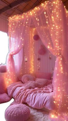 a pink bedroom with lights on the walls and bed canopy over it's headboard