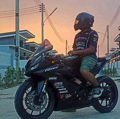 a man riding on the back of a black motorcycle