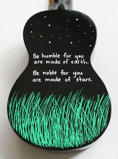 a black and green guitar case with an image of grass in the background that says, be humble for you are made of earth