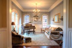 a living room filled with furniture and a grand piano