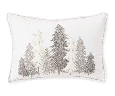 a white pillow with trees embroidered on the front and sides, along with a light gray border