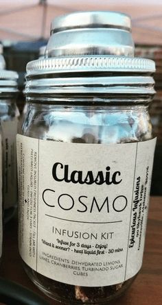 two mason jars with labels on them sitting on a table