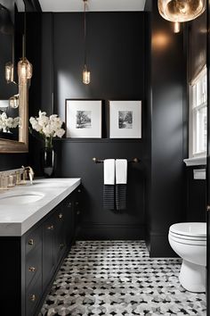 a black and white bathroom with gold accents, chandelier, sink, toilet and mirror