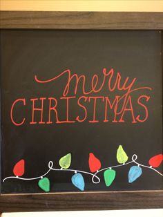 a chalk board with christmas lights on it