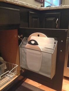 an open dishwasher sitting on top of a wooden floor