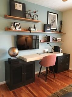 a home office with desk, chair and shelves on the wall in front of it