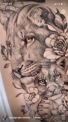 a tattoo with two lions and roses on it