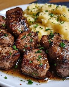 some meat and mashed potatoes on a white plate