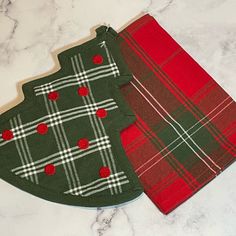 two green and red plaid cloths sitting on top of a white marble countertop