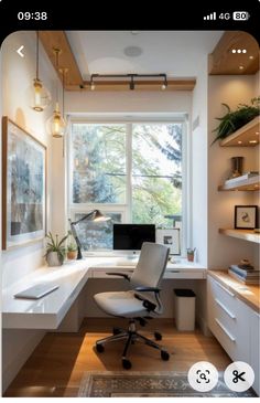 a home office with white furniture and wooden shelves on the wall, along with a large window