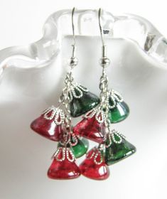 Red and Green Bells hanging from a chain bringing up the Holiday Jingle. Give the Christmas spirit as a gift or keep it for yourself, these earrings will be a great addition to your Christmas sweater . The earrings are 1.75in long (4.5cm) with Surgical Steel fishhook earwire. For larger selection you can visit my shop: http://www.etsy.com/shop/EvaLineJewelry?ref=si_shop Christmas Celebration Jewelry Drop Earrings, Christmas Celebration Drop Earrings Jewelry, Holiday Dangle Earrings With Ear Wire, Christmas Celebration Dangle Earrings, Christmas Dangle Jewelry For Celebration, Holiday Dangle Jewelry With Matching Earrings, Festive Holiday Jewelry With Dangle Shape, Christmas Party Dangle Jewelry, Red Dangle Holiday Jewelry