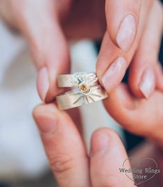 two people holding wedding rings in their hands