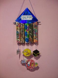 a wind chime hanging from the side of a pink wall with magnets attached to it