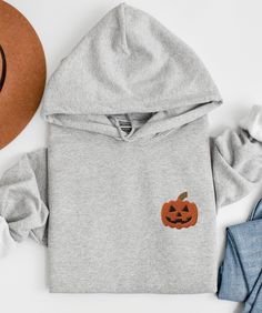 This cozy unisex hoodie is embroidered with a jack-o-lantern :)  * 50% pre-shrunk cotton, 50% polyester * Fabric weight: 8.0 oz/yd² (271.25 g/m²) * Air-jet spun yarn with a soft feel and reduced pilling * Double-lined hood with matching drawcord * Quarter-turned body to avoid crease down the middle * 1 × 1 athletic rib-knit cuffs and waistband with spandex * Front pouch pocket * Double-needle stitched collar, shoulders, armholes, cuffs, and hem SIZING: *Please ensure you check measurement chart Halloween Long Sleeve Sweatshirt With Drawstring Hood, Halloween Cotton Sweatshirt With Drawstring Hood, Embroidered Long Sleeve Hoodie For Fall, Halloween Embroidered Crew Neck Hoodie, Hooded Embroidered Sweatshirt For Halloween, Hoodie Embroidery, Embroidered Halloween, Stitch Hoodie, Embroidery Hoodie