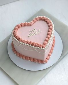 a pink heart shaped cake on top of a white plate