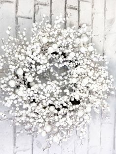 a bunch of white flowers sitting on top of a brick wall