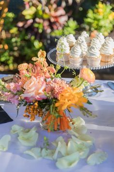 cupcakes and flowers sit on a table