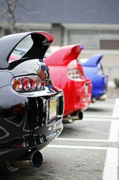 several cars parked in a parking lot with their hoods down and the lights on