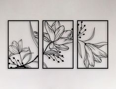 three black and white floral paintings on a wall