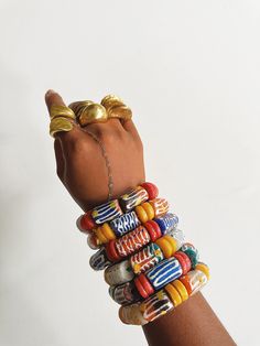 De beaux bracelets africains élégants faits à la main en verre par des artisans ghanéens. Ils sont disponibles dans une variété de combinaisons de couleurs et de motifs uniques, plus vous en portez, mieux c'est. Tailles : Large 3/4 po. L *Veuillez noter que ces bracelets sont plus grands et plus lourds que nos bracelets originaux pour personnages (voir les photos pour la différence de taille), 6 de ces bracelets = 1 lb. Chaque bracelet est unique en son genre et convient aux poignets 6-7. Dispon African American Bracelets, Ghana Bracelet, East African Bracelets, African Trade Bead Bracelet, Afrocentric Accessories, Cowrie Shell Jewelry, African Bracelets, Boho Statement Necklace, Heart Accessories