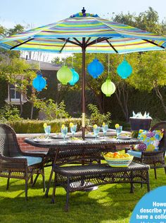 an outdoor table with chairs and umbrella in the grass