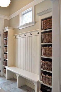 a white bench sitting in the middle of a room filled with lots of drawers and baskets