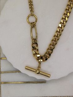 "Curb Gold This is a beautiful super trendy necklace for layering and for everyday wear. * DETAILS * ✤ Available in 14k Gold plated over brass ✤ Model is wearing size 16\" ✤ Toggle bar hang as a charm ✤ Available in Size 16\" 18\" and 20\" * PACKAGING * - Purchase is packaged in a Tommassini Jewelry box. - If you purchase more than one item, I will place it all into one box, unless requested otherwise in a note. * DON'T FORGET US * Instagram: https://instagram.com/tommassini_jewelry Facebook: ht Modern Gold Curb Chain Necklace, Chunky Oval Link Necklace As A Gift, Chunky Oval Link Necklace For Gift, Gold Curb Chain Jewelry For Layering, Modern Chunky Chain Necklace Gift, Chunky Chain Choker Necklace As A Gift, Chunky Chain Choker Necklace For Gift, Gold Toggle Necklace With Chunky Chain In Chic Style, Gold Toggle Necklace With Chunky Chain, Chic Style