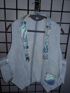 "This handmade vest is made out of recylced blue jeans.  Super fun!  If you like individuality, you'll love it.  I put medium as a size but these vests fits most.  The look is a bit different on my 5'1\" small busted frame than a 5'8\" gal with a larger bust.  I personally think they look even better on larger gals.  Just saying'!  But I love mine as well." Spring Denim Vest With Pockets In Recycled Material, Recycled Denim Vest With Pockets In Denim Blue, Patchwork Denim Sleeveless Vest, Spring Medium Wash Recycled Denim Vest, Casual Festival Vest With Pockets, Bohemian Sleeveless Denim Vest, Festival Cotton Denim Vest With Pockets, Blue Patchwork Vest For Spring, Casual Denim Patchwork Vest