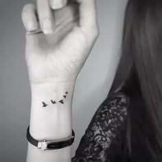 a woman's wrist tattoo with birds flying in the sky on her left arm