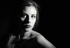 a black and white photo of a woman's face with long hair in the dark