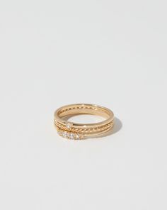 a gold ring with three small diamonds on the side, set against a white background