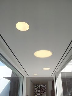 an empty hallway with three round lights on the ceiling