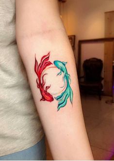 a woman with a tattoo on her arm that has two goldfishs in it