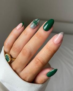 a woman's hand with green and white manicures on it, wearing a ring