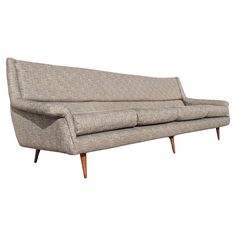 a gray couch sitting on top of a wooden frame