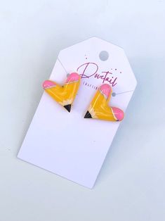 pair of pink and yellow heart shaped earrings on white tag with red lettering that says douteti