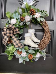 a wreath with snow boots and greenery hangs on the front door's black door