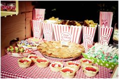 a table topped with lots of pies and cupcakes next to each other