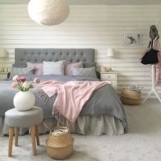 a bed room with a neatly made bed and two stools next to the bed