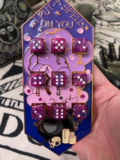 a purple and pink pin with lots of dice on it