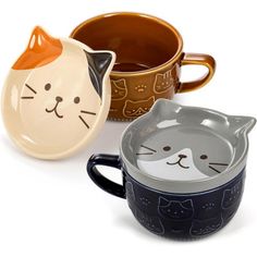 three ceramic mugs with cat faces on them