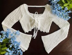 a white knitted sweater with blue flowers around it