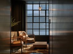 a living room filled with furniture next to a tall glass window covered in light shinning