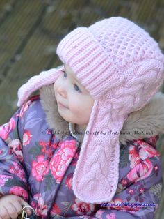 a small child wearing a pink hat and scarf