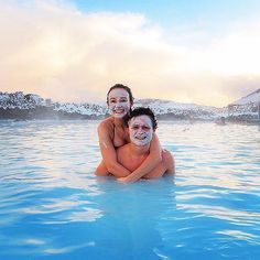 two people are in the water with their arms around each other and one person is smiling