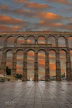 an arch in the middle of a large stone structure with multiple arches on each side