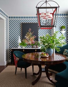 a dining room with blue chairs and a wooden table in front of a patterned wall